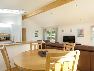 a kitchen and a living room with a wooden table at 3 Valley View in Looe