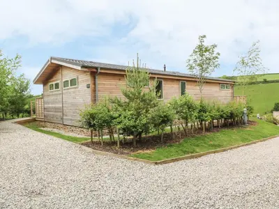 a house with a row of trees in front of it at 3 Valley View in Looe