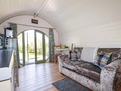 a living room with a couch and an open door at The Lamb Shack in Bodmin