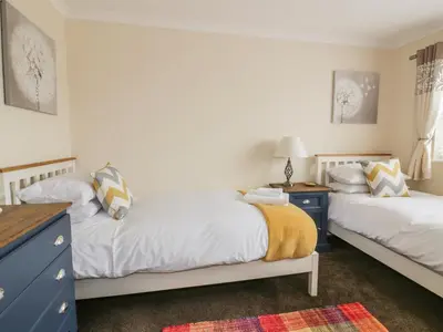 a bedroom with two beds and a blue dresser at Dune Haven in Truro