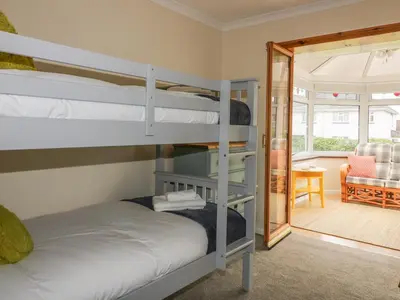 a bedroom with bunk beds and a living room at Dune Haven in Truro