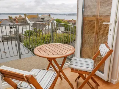 a table and two chairs on a balcony with a view at Mount View Cottage in Marazion
