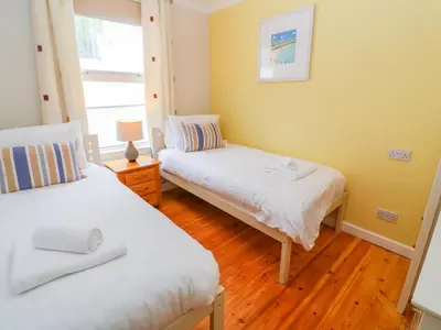 a bedroom with two beds and a window at Mount View Cottage in Marazion