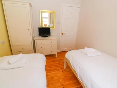 a bedroom with two beds and a television in it at Mount View Cottage in Marazion