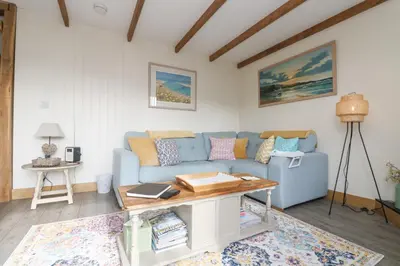 a living room with a blue couch and a table at The Lily Pad in Camborne