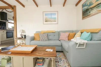 a living room with a couch and a table at The Lily Pad in Camborne