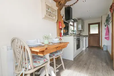 a kitchen with a wooden table and chairs at The Lily Pad in Camborne