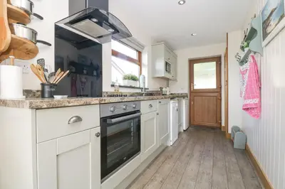 a kitchen with white cabinets and a stove at The Lily Pad in Camborne