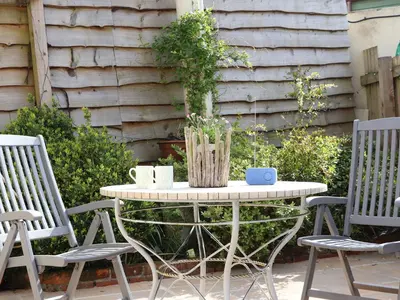 a patio table with two chairs and a table with two cups at The Lily Pad in Camborne