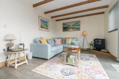 a living room with a blue couch and a table at The Lily Pad in Camborne