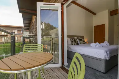 a bedroom with a bed and a table and chairs at Sea Breeze 17 Gannel in Truro