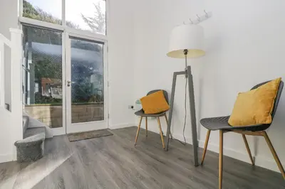 two chairs and a floor lamp in a room with a window at Sea Breeze 17 Gannel in Truro