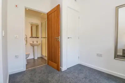 a bathroom with a toilet and a wooden door at Sea Breeze 17 Gannel in Truro
