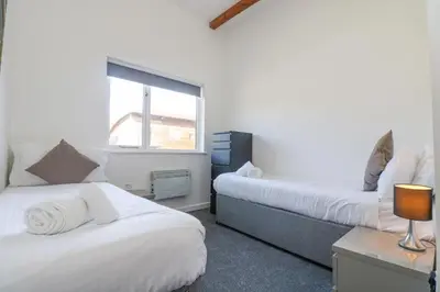 a bedroom with two beds and a window at Sea Breeze 17 Gannel in Truro