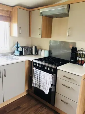 a kitchen with a stove top oven in a kitchen at B47 Caravan Seven Bays in Padstow
