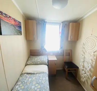 a small bedroom with two beds and a window at B47 Caravan Seven Bays in Padstow
