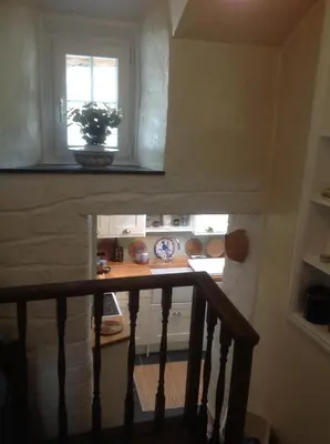 a staircase with a window and a table in a room at Jasmine Cottage in Lerryn