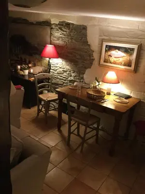 a table and chairs in a room with a stone wall at Jasmine Cottage in Lerryn