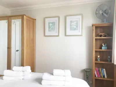 a bedroom with a pile of towels on a bed at Falmouth View in Falmouth
