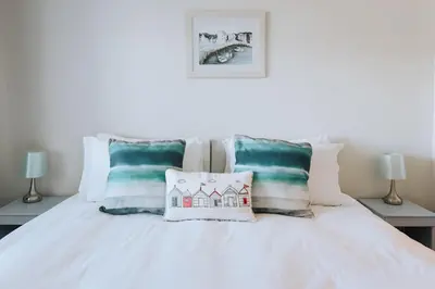 a bedroom with a white bed with pillows on it at Falmouth View in Falmouth