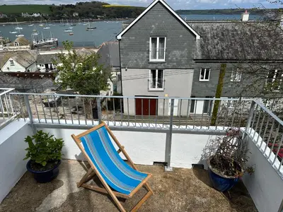 a blue chair sitting on a balcony with a house at Falmouth View in Falmouth