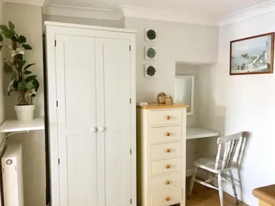 a bedroom with a white cabinet and a dresser at Falmouth View in Falmouth