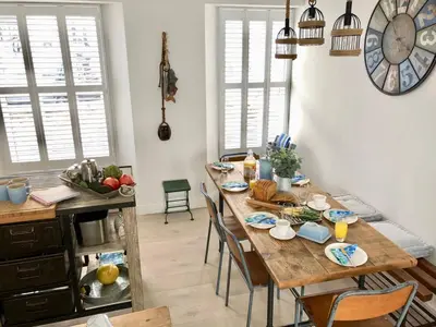 a dining room with a table with chairs and a clock at Jacob's View in Falmouth