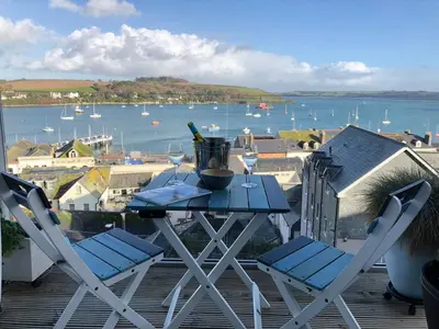 a table and chairs on a balcony with a view of the water at Jacob's View in Falmouth