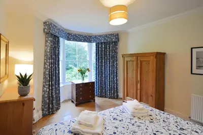 a bedroom with a bed and a large window at Rosevean House in St. Agnes