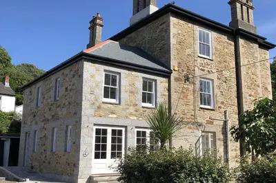 an old brick building with two chimneys on top at Rosevean House in St. Agnes