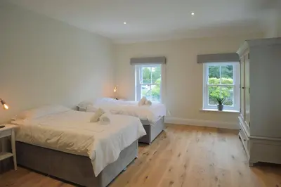 two beds in a room with two windows at Rosevean House in St. Agnes