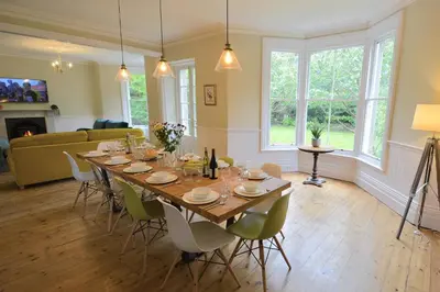 a dining room with a long table and chairs at Rosevean House in St. Agnes