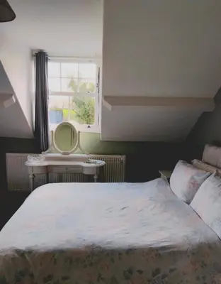 a bedroom with a bed and a window and a mirror at The Countryman Hotel in Camelford