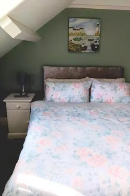 a bedroom with a bed with a floral bedspread at The Countryman Hotel in Camelford
