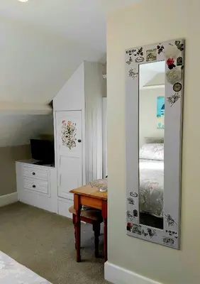 a bedroom with a mirror and a table with a bed at The Countryman Hotel in Camelford