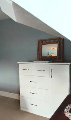 a white dresser in a bedroom with a mirror at The Countryman Hotel in Camelford