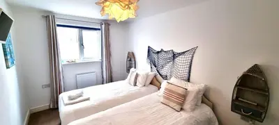 a bedroom with two beds and a window at Ocean View in Perranporth
