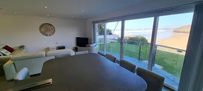 a dining room with a table and a view of the ocean at Ocean View in Perranporth