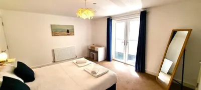 a room with a bed and a mirror and a window at Ocean View in Perranporth
