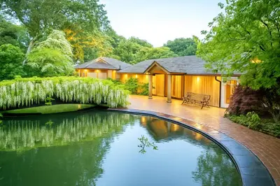 a house with a swimming pool in the yard at Pinetum Garden Cottages in St Austell