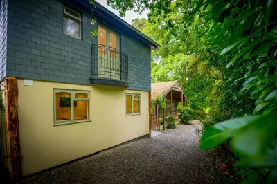 a side view of a house with a balcony at Pinetum Garden Cottages in St Austell
