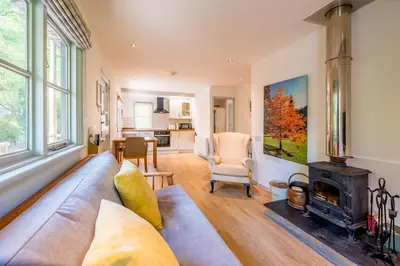 a living room with a couch and a fireplace at Pinetum Garden Cottages in St Austell