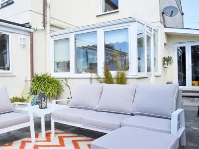a white couch in front of a house at Bay Cottage in Par
