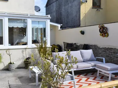 a patio with a couch and a table at Bay Cottage in Par