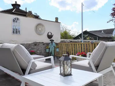 a patio with two chairs and a table at Bay Cottage in Par