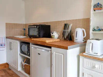 a kitchen with a counter top with a microwave at Bay Cottage in Par