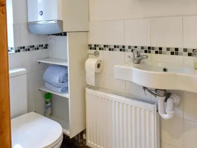 a bathroom with a sink and a toilet at Bay Cottage in Par