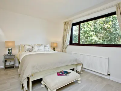 a bedroom with a bed and a large window at Hawks Ridge in Downderry