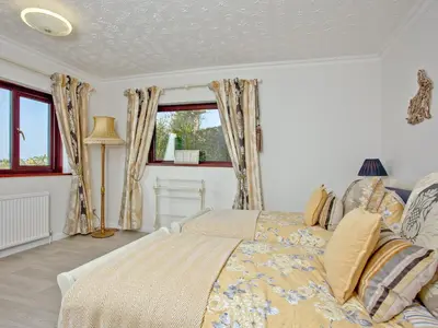 a bedroom with a bed and a window at Hawks Ridge in Downderry