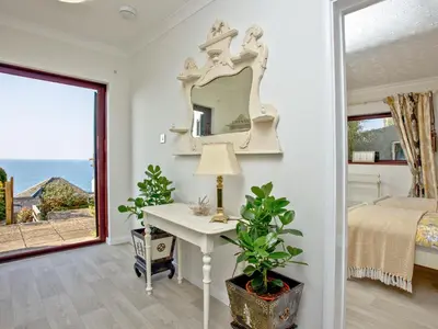 a bedroom with a bed and a table with a mirror at Hawks Ridge in Downderry